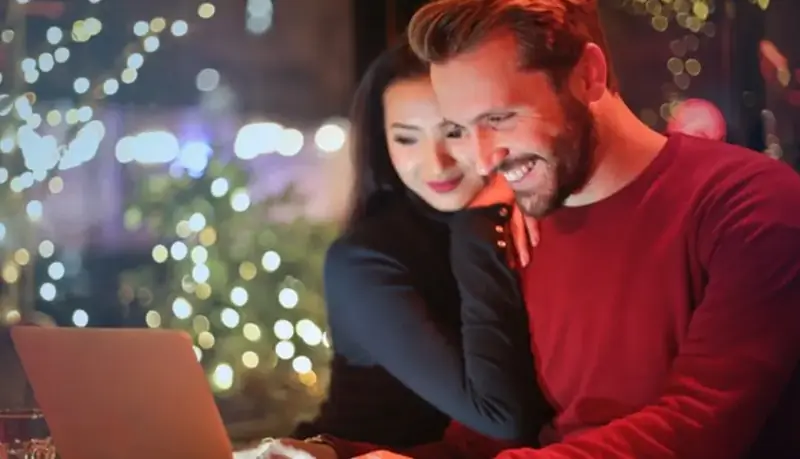 Couple researching spots for expats in Dubai on a laptop